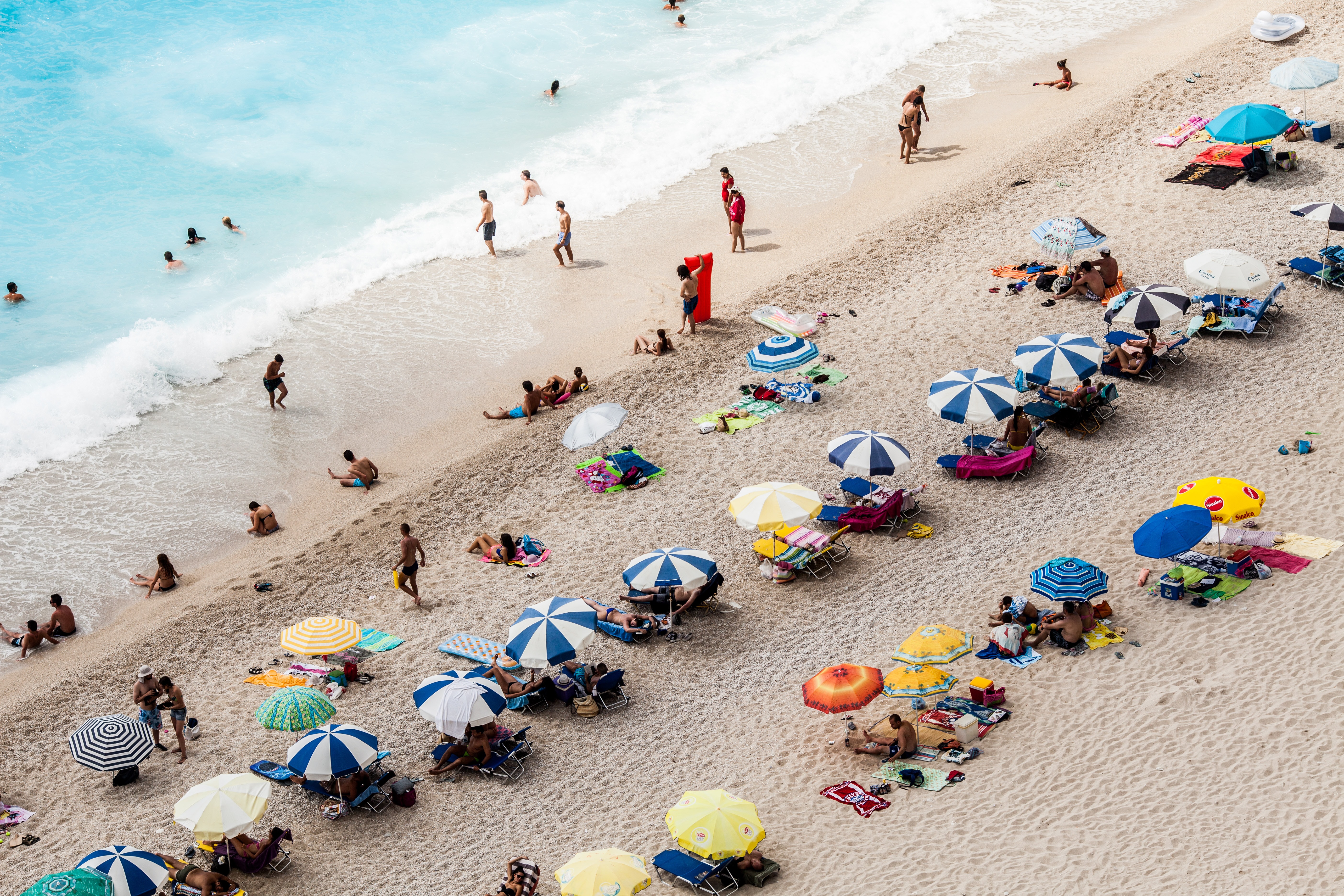 Где отдыхать в мае недорого. Туристы на пляже. Пляж Микхе. Летний пляжный отдых. Товары для пляжного отдыха.